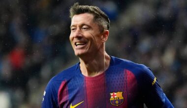 Piłkarz FC Barcelony, Robert Lewandowski, biegnie po boisku z uśmiechem na twarzy.