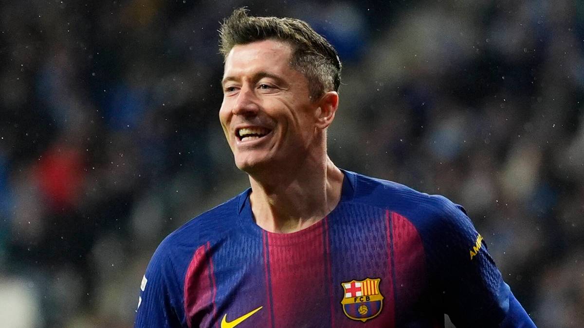 Piłkarz FC Barcelony, Robert Lewandowski, biegnie po boisku z uśmiechem na twarzy.