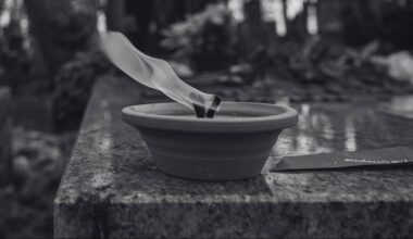 Płonący znicz na nagrobku.