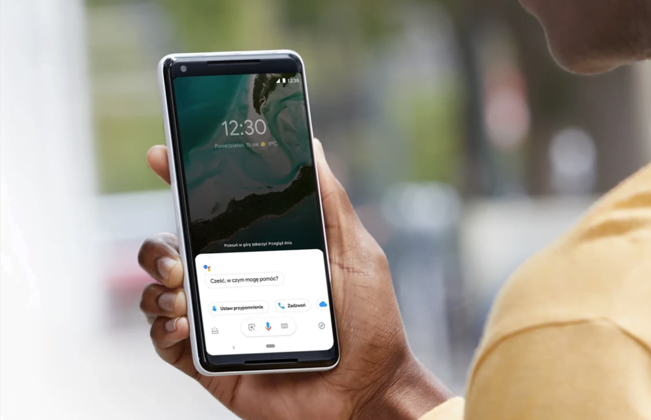 Osoba trzymająca smartfon pokazujący ekran z wirtualnym asystentem oferującym pomoc i opcje interakcji.