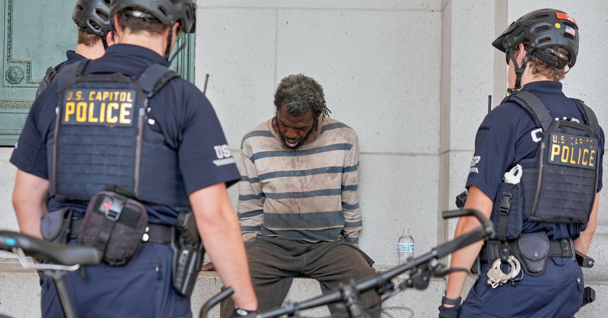 Funkcjonariusze policji Kapitolu Stanów Zjednoczonych rozmawiają z bezdomnym mężczyzną, Waszyngton, USA, 22 sierpnia 2025 r.