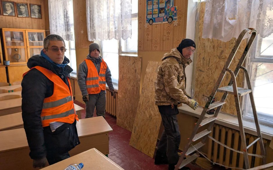 Federico Cavallieri (na zdjęciu po lewej) i jego przyjaciele (po prawej wolontariusz z Rumunii) odpowiedzieli na prośbę dyrektora szkoły, by zabezpieczyć wybite przez Rosjan okna. / Fot. NV/Ołeksandr Paschover