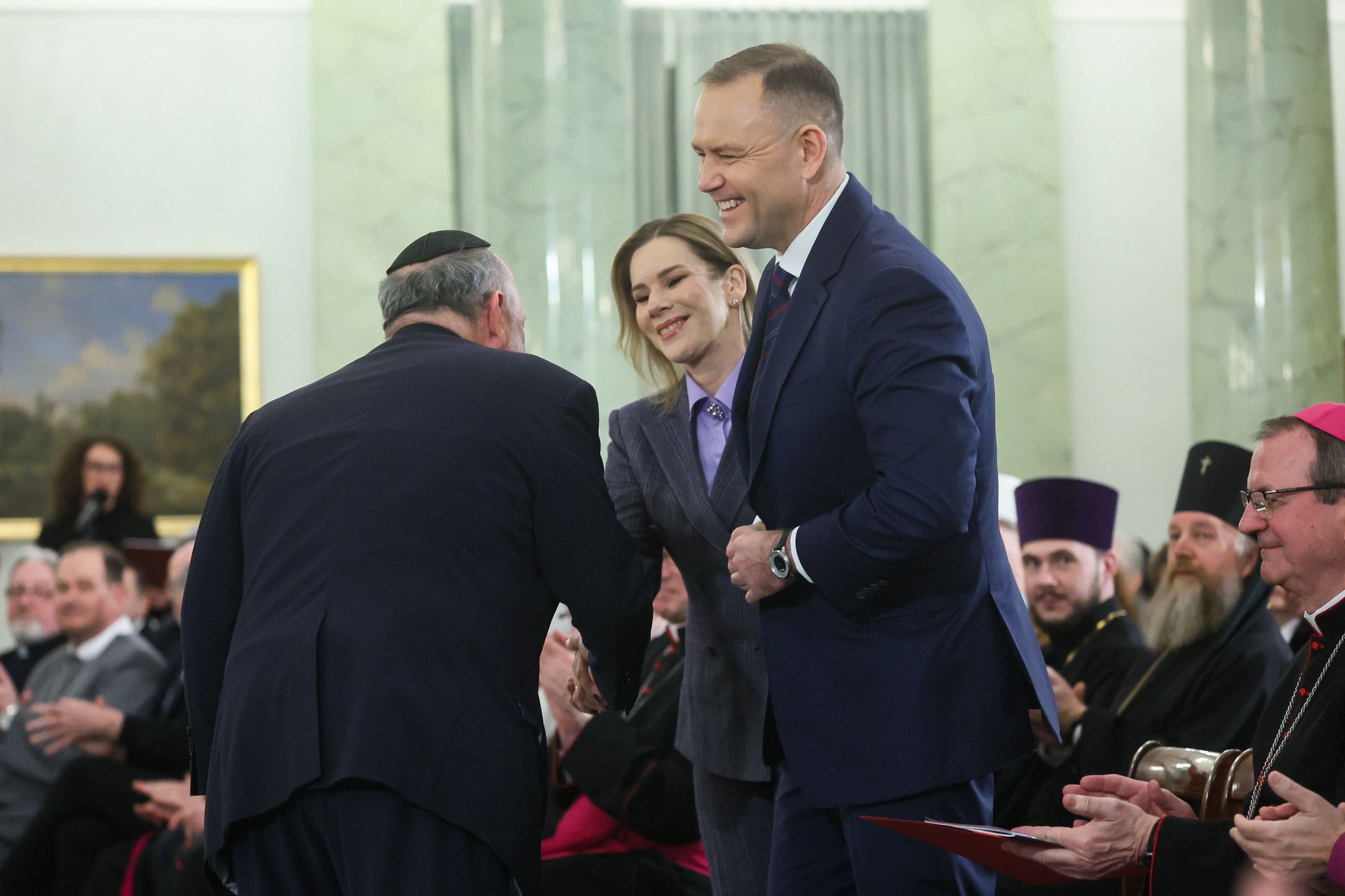 Warszawa, 14.01.2026. Prezydent RP Karol Nawrocki (C-P), pierwsza dama Marta Nawrocka (C) i naczelny Rabin Polski Michael Schudrich (C-L) na spotkaniu noworocznym z przedstawicielami kościołów i związków wyznaniowych oraz mniejszości narodowych i etnicznych w Polsce, 14 bm. w Pałacu Prezydenckim w Warszawie. (sko) PAP/Leszek Szymański