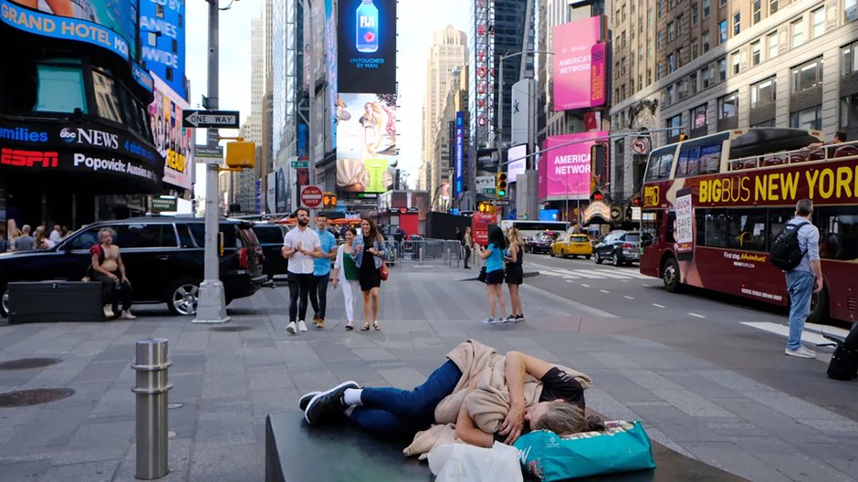 Młoda kobieta w kryzysie bezdomności śpi na ulicy na Times Square, Nowy Jork, USA,