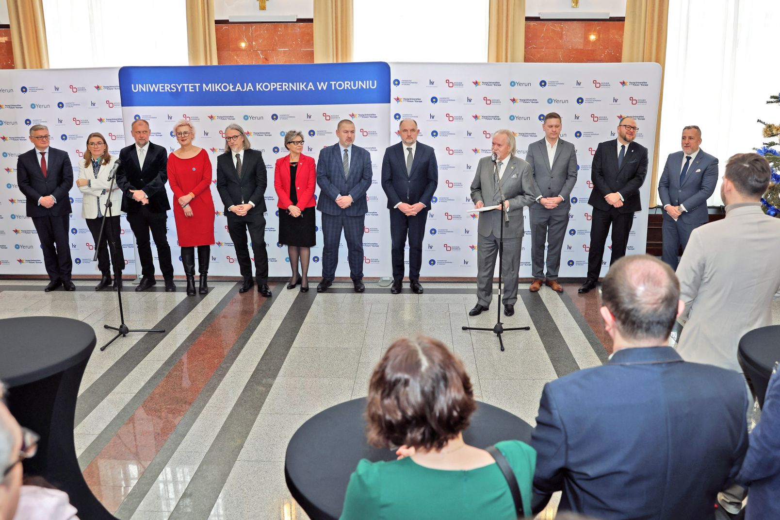 Rektor UMK przy mikrofonie, za nim zaproszeni goście: prezydent miasta, marszałek, wojewoda oraz przedstawiciele władz UMK