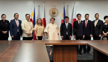 Grupa urzędnik&oacute;w państwowych Japonii i Filipin pozuje do zdjęcia na tle flag obu kraj&oacute;w.