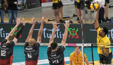 Siatkarze rywalizujący w meczu, jeden z graczy wykonuje atak nad siatką.