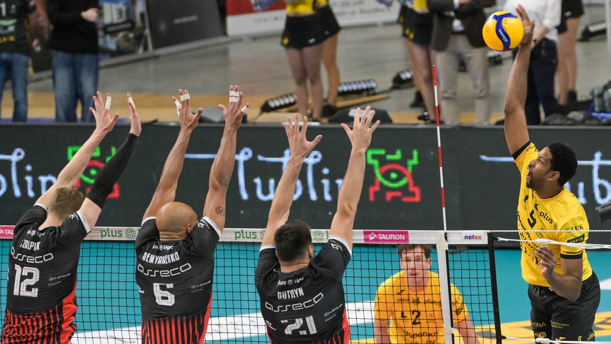 Siatkarze rywalizujący w meczu, jeden z graczy wykonuje atak nad siatką.