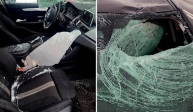 Fragment wnętrza BMW z lodem na siedzeniu, obok rozbita przednia szyba samochodu z kawałkami lodu.