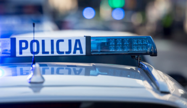 Niebieskie światła policyjne na dachu radiowozu z napisem POLICJA