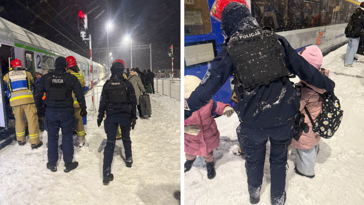 Służby ratownicze i policja pomagają pasażerom ewakuować się z pociągu stojącego na zaśnieżonym torowisku.