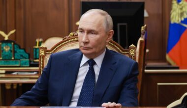 Władimir Putin siedzi przy biurku w gabinecie.