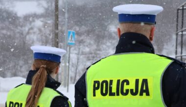 Dw&oacute;ch policjant&oacute;w w kamizelkach odblaskowych z napisem POLICJA.