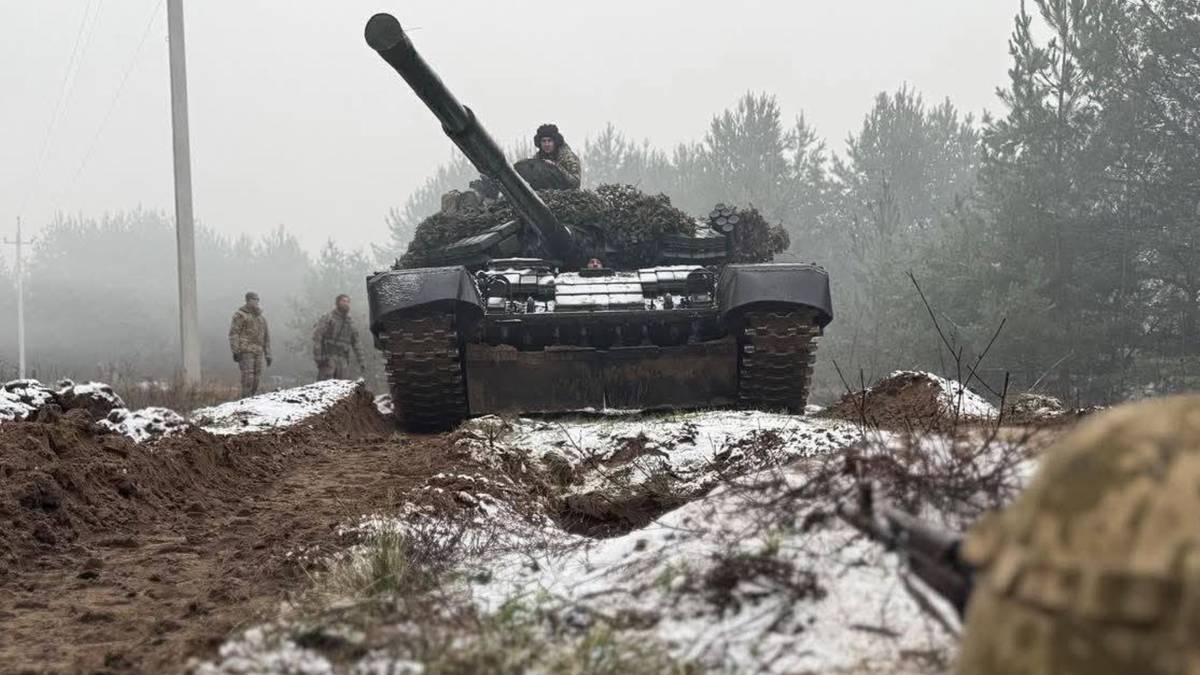 Czołg z żołnierzami na tle zimowego krajobrazu leśnego.