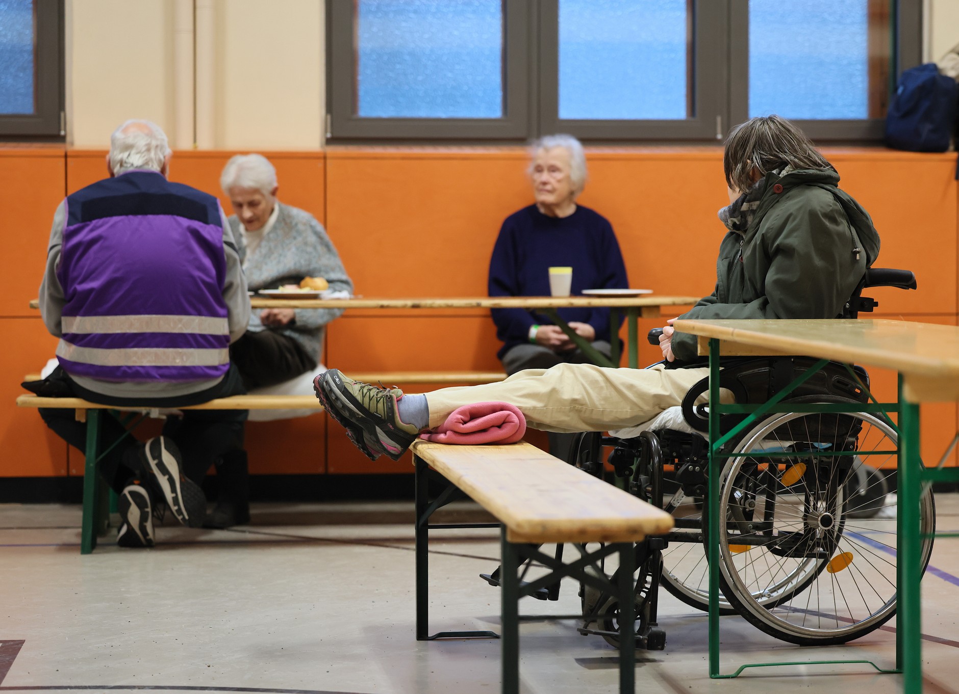 Ludzie siedzą w schronisku awaryjnym w sali gimnastycznej szkoły podczas przerwy w dostawie prądu w południowo-zachodniej części Berlina, 5 stycznia 2026 r.