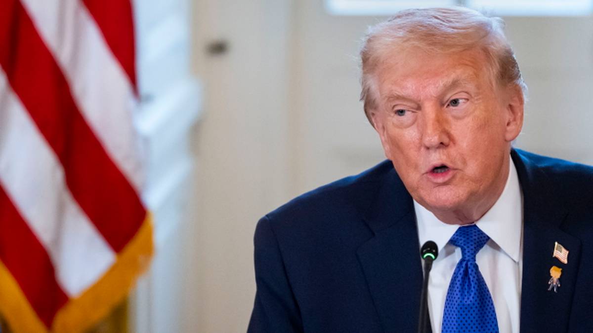 Donald Trump przemawia obok amerykańskiej flagi.