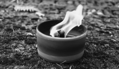 Płonący znicz na kamiennym podłożu.