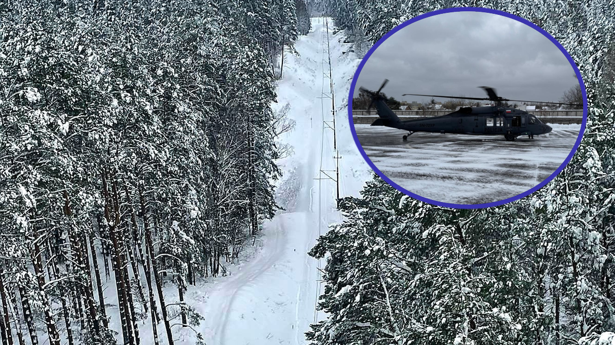Policyjny śmigłowiec Black Hawk wylądował na tle zimowego krajobrazu z zasypanymi śniegiem drzewami i torami kolejowymi.