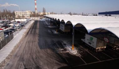 Zadaszony parking pokryty śniegiem z zaparkowanymi samochodami.