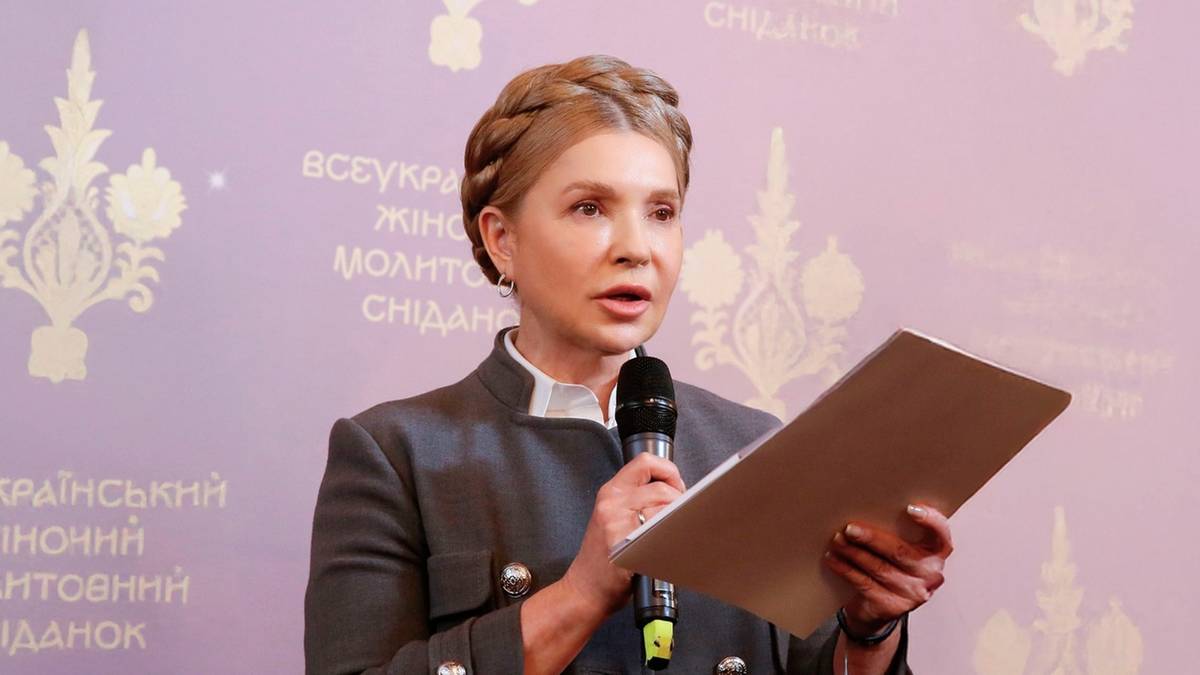 Julia Tymoszenko przemawia do mikrofonu z dokumentami w ręku.