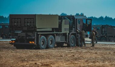 Samoch&oacute;d ciężarowy z zamontowanym systemem rakietowym na tle lasu.