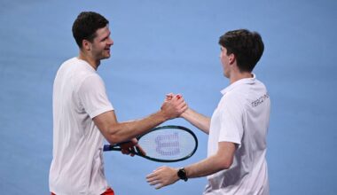 Dw&oacute;ch tenisist&oacute;w ściska sobie dłonie na korcie, jeden z nich trzyma rakietę.