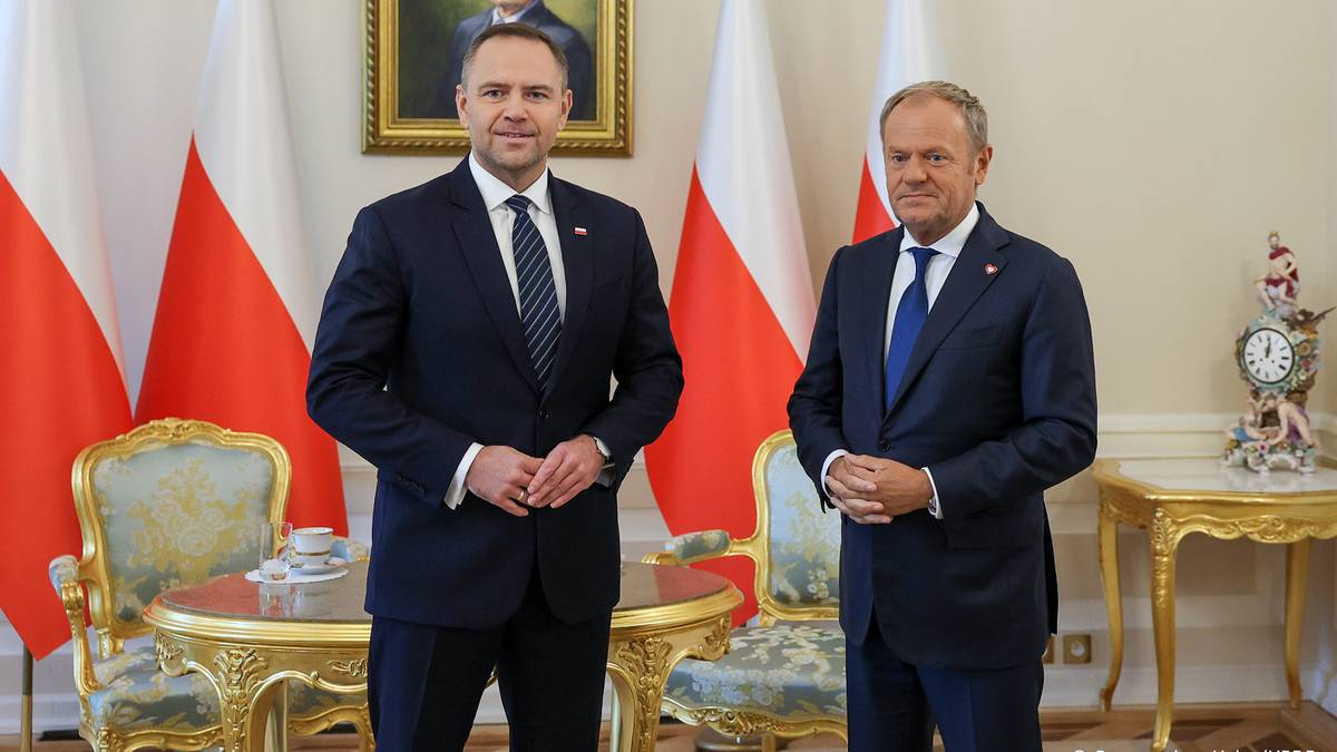 Prezydent Andrzej Duda i premier Donald Tusk stoją obok siebie w sali ceremonialnej.