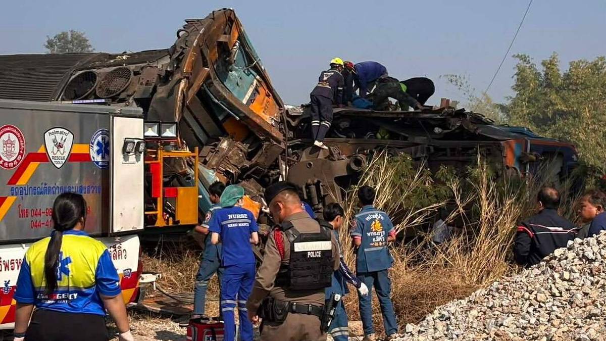 Zniszczony wagon kolejowy na miejscu wykolejenia w Tajlandii, wok&oacute;ł pracują ratownicy i służby porządkowe.