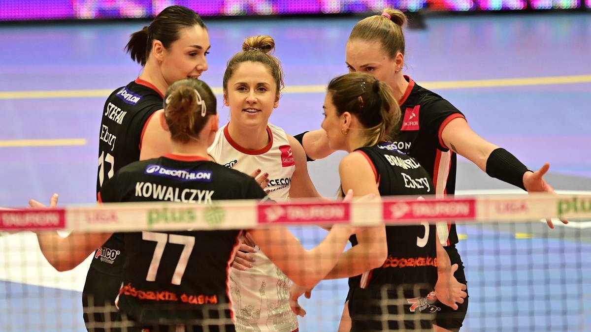 Grupa siatkarek po meczu, jedna z nich uśmiecha się do drugiej.