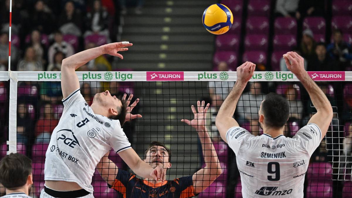 Siatkarze wykonują blok podczas meczu.