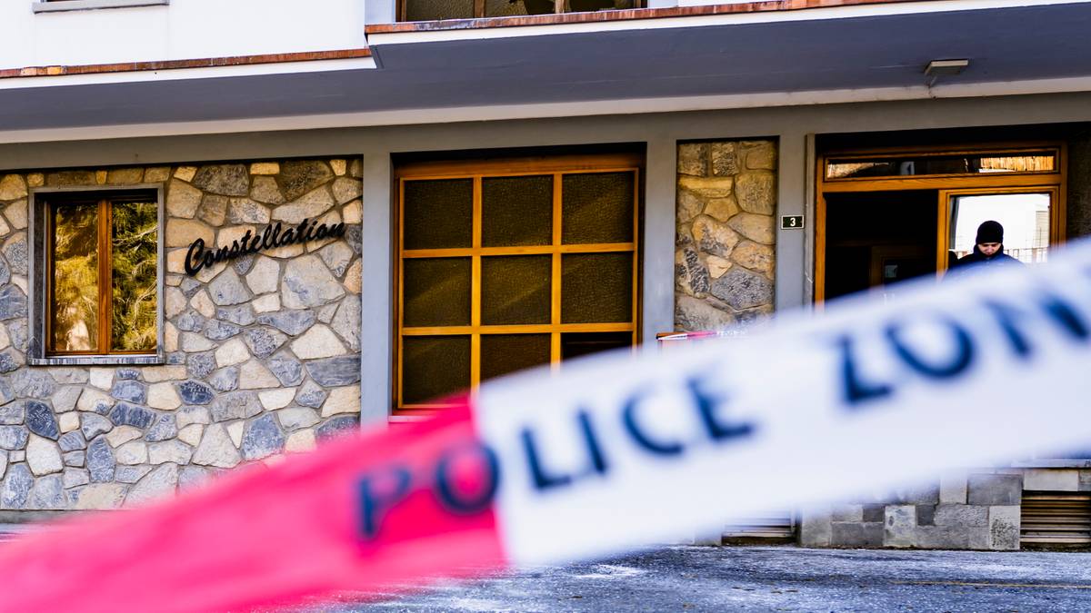 Budynek z kamienną fasadą, z napisem "Constellation" po lewej stronie. Na pierwszym planie widoczna jest taśma policyjna z napisem "POLICE ZONE". W tle, w otwartych drzwiach budynku, stoi osoba ubrana w ciemną kurtkę.