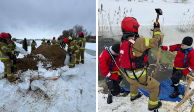 Strażacy pracują w zasypanym śniegiem terenie, układając worki z piaskiem w pobliżu przerwanego wału.