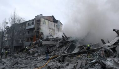 Gruzowisko zniszczonej kamienicy, z kt&oacute;rej unosi się dym, widoczni strażacy na miejscu zdarzenia.