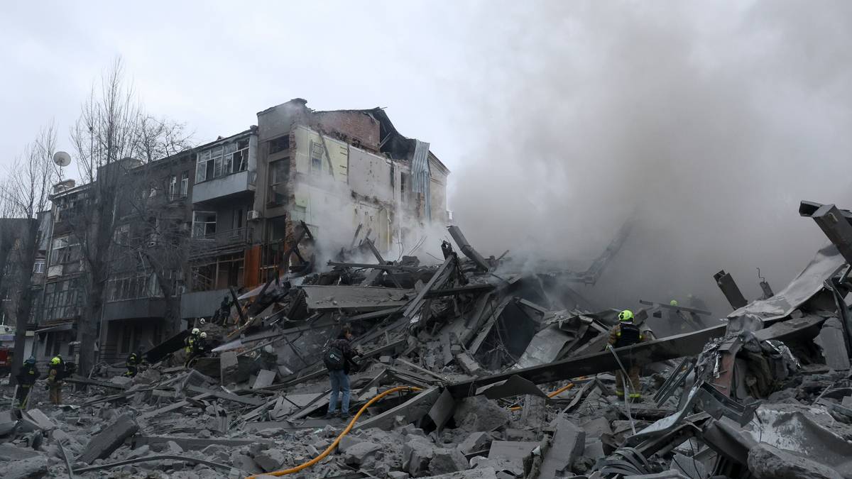 Gruzowisko zniszczonej kamienicy, z kt&oacute;rej unosi się dym, widoczni strażacy na miejscu zdarzenia.