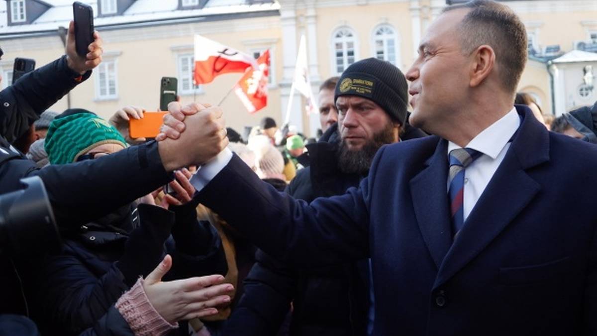 Karol Nawrocki, prezes IPN, ściska dłoń mężczyźnie w czapce na Jasnej G&oacute;rze.