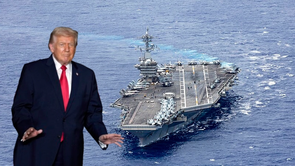 Zdjęcie przedstawia Donalda Trumpa stojącego na pierwszym planie po lewej stronie, z wyciągniętymi rękami. W tle, na wodzie, widoczny jest duży amerykański lotniskowiec.