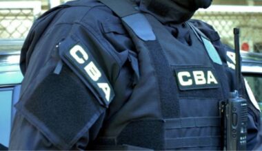 Funkcjonariusz CBA w mundurze z naszywkami CBA i radiotelefonem.