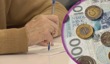 Dłoń seniora pisząca na dokumencie obok polskich pieniędzy.
