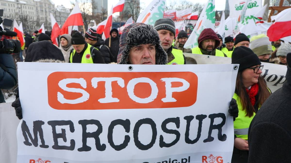 Transparent z napisem STOP MERCOSUR na tle protestujących os&oacute;b.