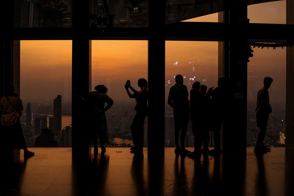 Ludzie podziwiają panoramę Bangkoku o zmierzchu w sylwestra w Bangkoku w Tajlandii, 31 grudnia 2025 r.