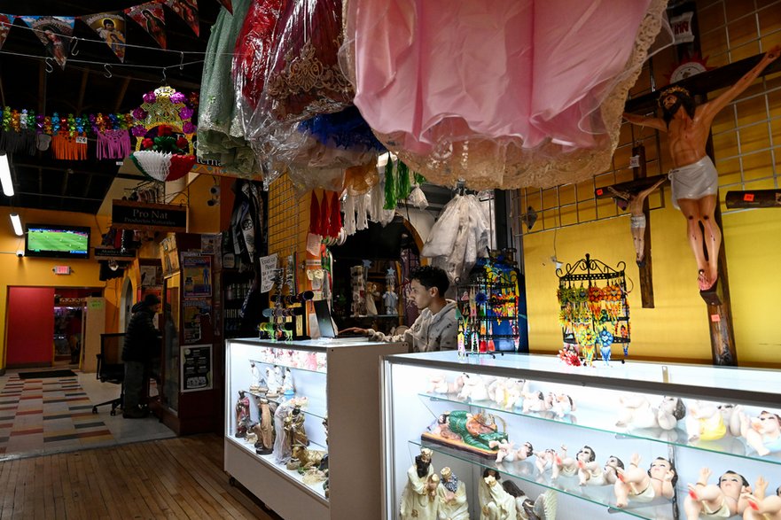 Chłopiec pracujący w sklepie odzieżowym swojej matki na targu Mercado Central w Minneapolis w stanie Minnesota, 16 stycznia 2025 r.