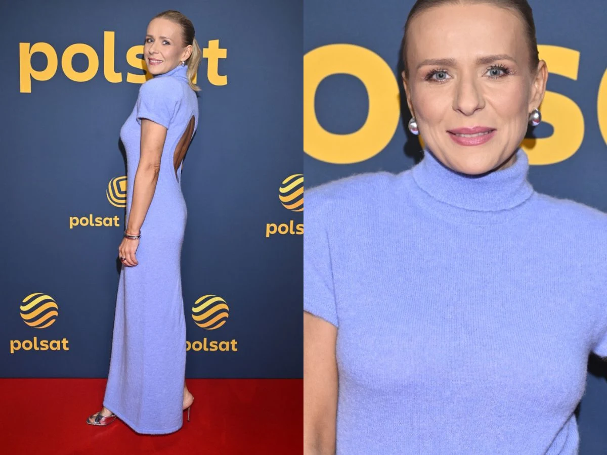 Kobieta w długiej, jasnofioletowej sukni z krótkim rękawem pozuje na tle ścianki z logo telewizji Polsat, uśmiecha się i patrzy w stronę aparatu, jej fryzura jest gładko zaczesana do tyłu, biżuteria składa się z kolczyków.