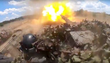 Wybuch w terenie pag&oacute;rkowatym z widocznym na pierwszym planie fragmentem sprzętu wojskowego.