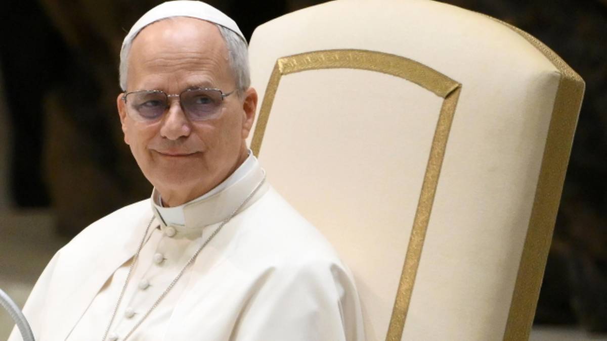 Portret papieża Leona XIV siedzącego na krześle, ubranego w białą sutannę.