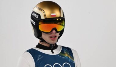 Portret skoczka narciarskiego w kasku i goglach, skierowany w stronę widza.