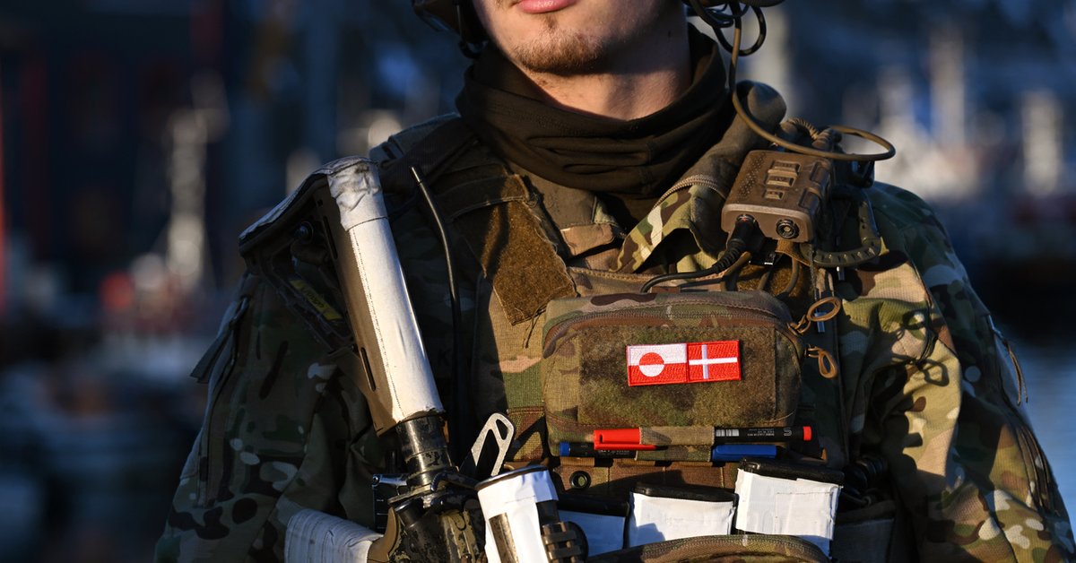 Duński żołnierz z flagami Grenlandii  (L) i Danii (P) na mundurze na posterunku kontrolnym w porcie Nuuk na Grenlandii, 26 stycznia 2026 r.
