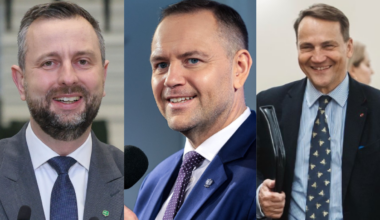 Trzech polityk&oacute;w w garniturach, z czego dw&oacute;ch uśmiechniętych.