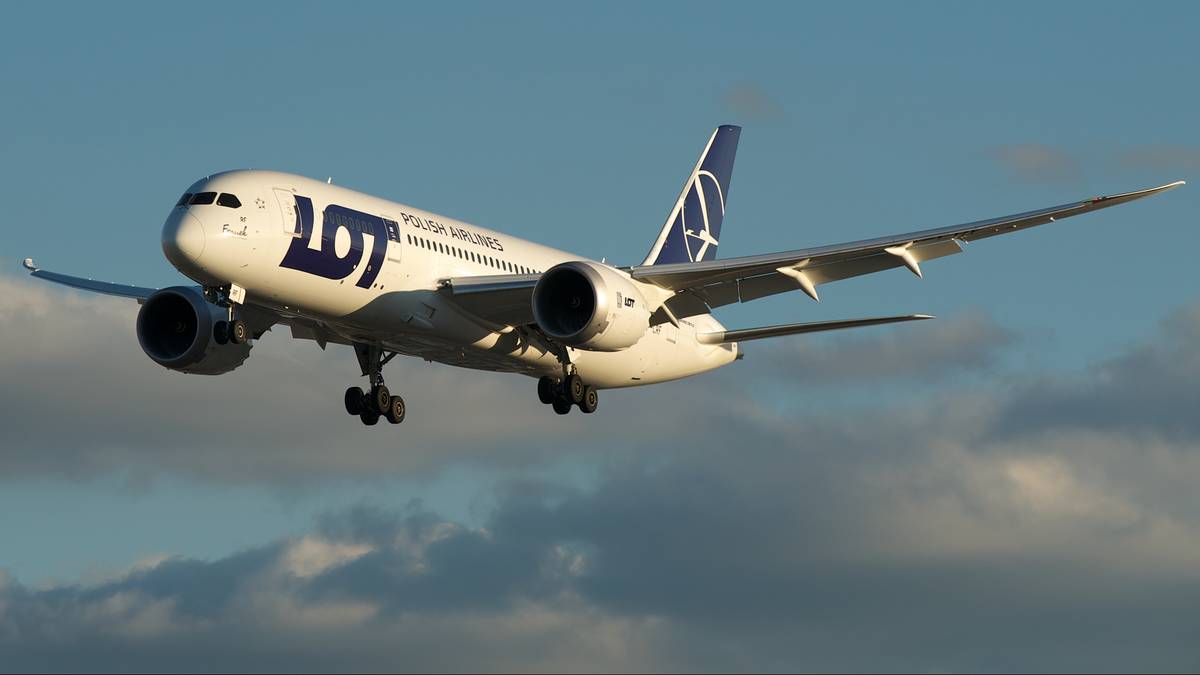 Samolot PLL LOT z widocznym podwoziem w locie na tle błękitnego nieba z chmurami