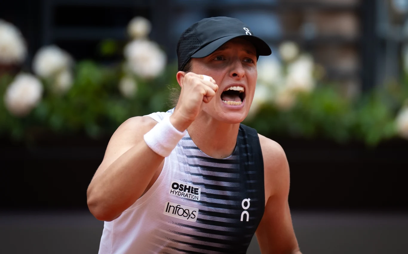 Tenisistka w czapce sportowej i koszulce bez rękawów z zaciśniętą pięścią wyraża silne emocje podczas meczu.