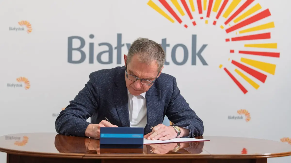 Andrzej Poczobut podpisuje wniosek o wynajęcie mieszkania w Białymstoku